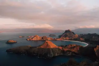 Illustration: A panoramic view of rugged islands and bays in Komodo National Park during sunset.