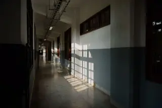 Illustration: Sunlight casting window shadows along an empty building corridor.