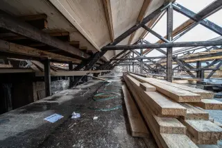 Illustration: Wooden beams and planks stored in an attic under construction.