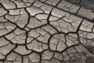 Illustration: Close-up view of parched, deeply cracked dry earth.